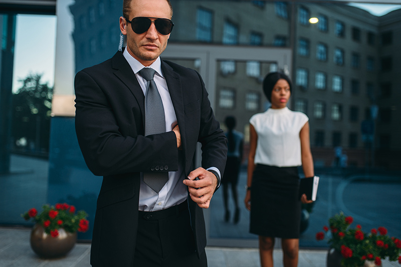 Serious bodyguard in suit, sunglasses and earpiece